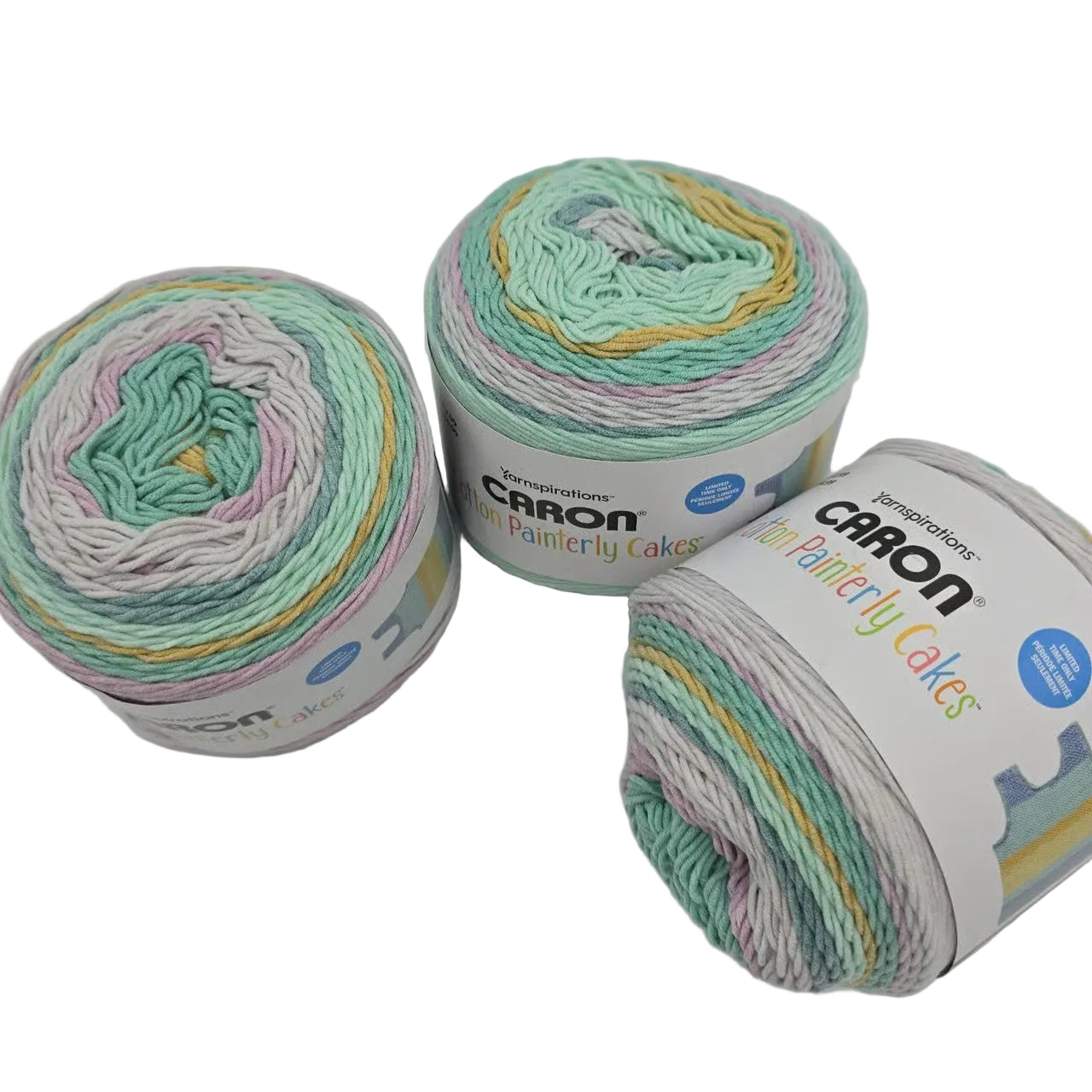 Image of 3 cakes of Caron Cotton Painterly Cakes yarn in the color Turquoise Thrill with labels on a white background.