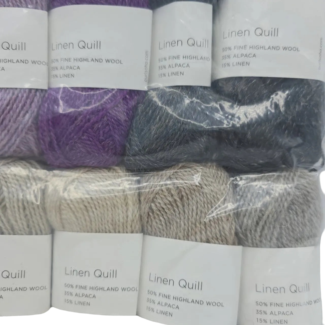 Close-up Image of a set of mini skeins of Purl Soho Linen Quill Yarn Set of 10 Minis in Purple & Neutral colors with labels on a white background.