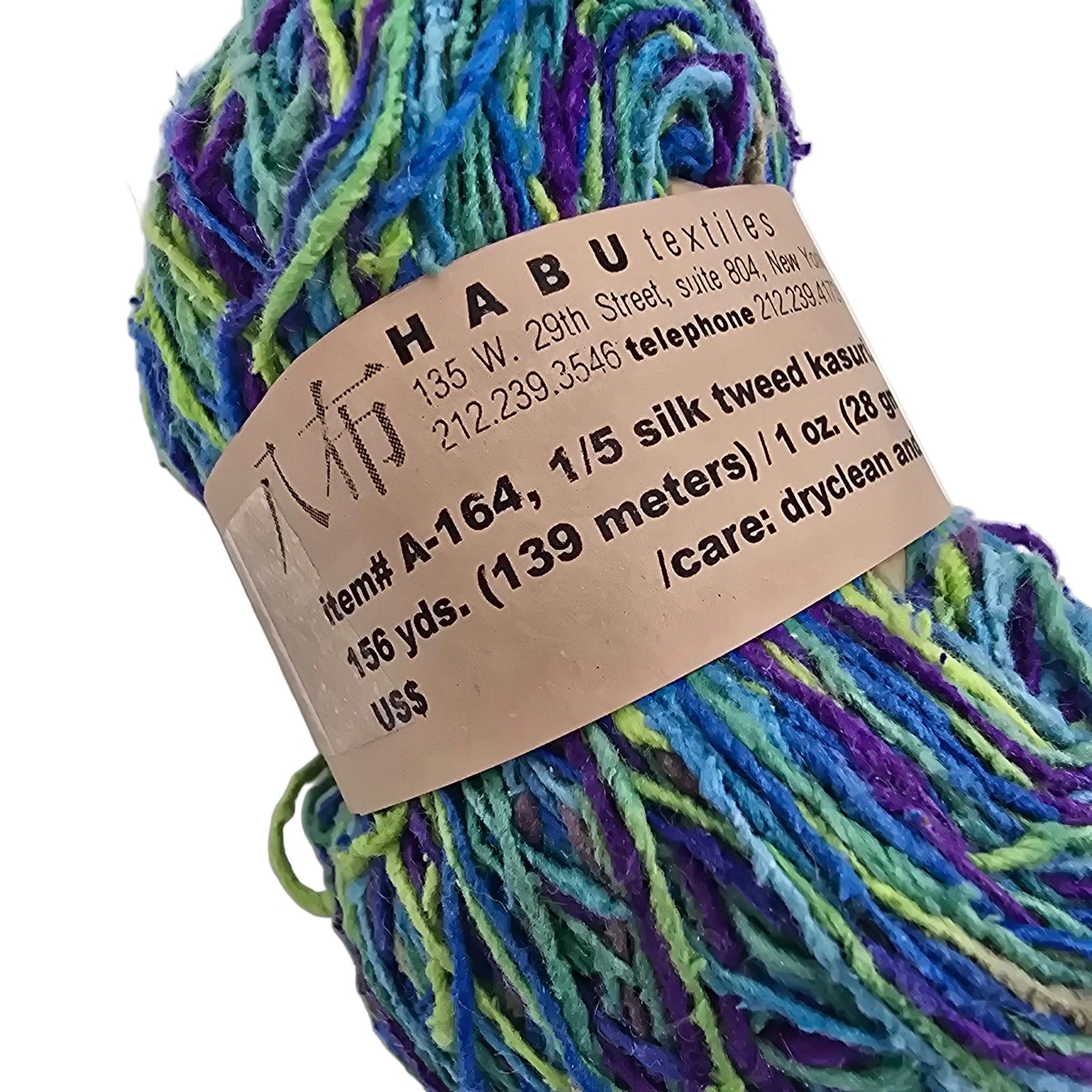 Close-up Image of a single hank of A-164 1/5 Silk Tweed Kasuri Yarn by Habu Textiles in the Color L9 with label on a white background.