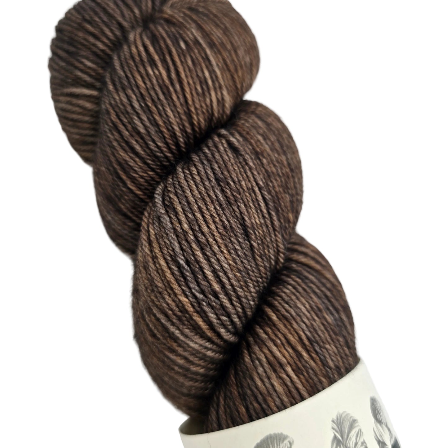 Close-up image of a single skein of House DK yarn by House of a La Mode -in the color Moto: The Semi Smokey Collection with a partial label on a white background.