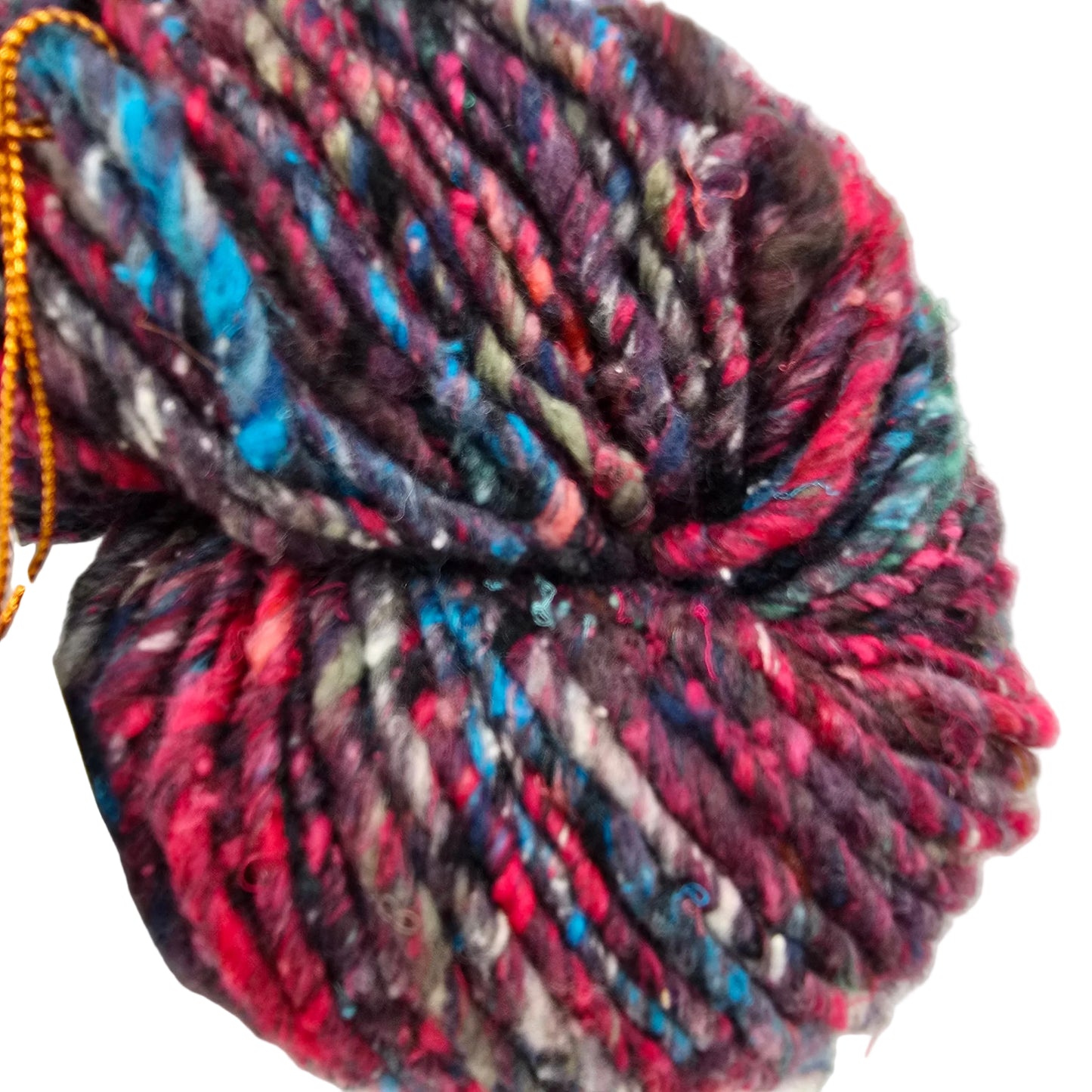 A close-up of Kogarashi_Yarn_by_Noro_-in Color_8 a variegated yarn, featuring a marled mix of dark purple, bright pink, teal blue, and gray fibers on a white background.