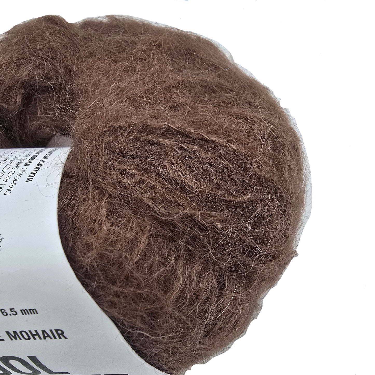 Close-up Image of a single ball of Take Care Mohair Yarn by Wool And The Gang the color Chocolate Brown with label on a white background.