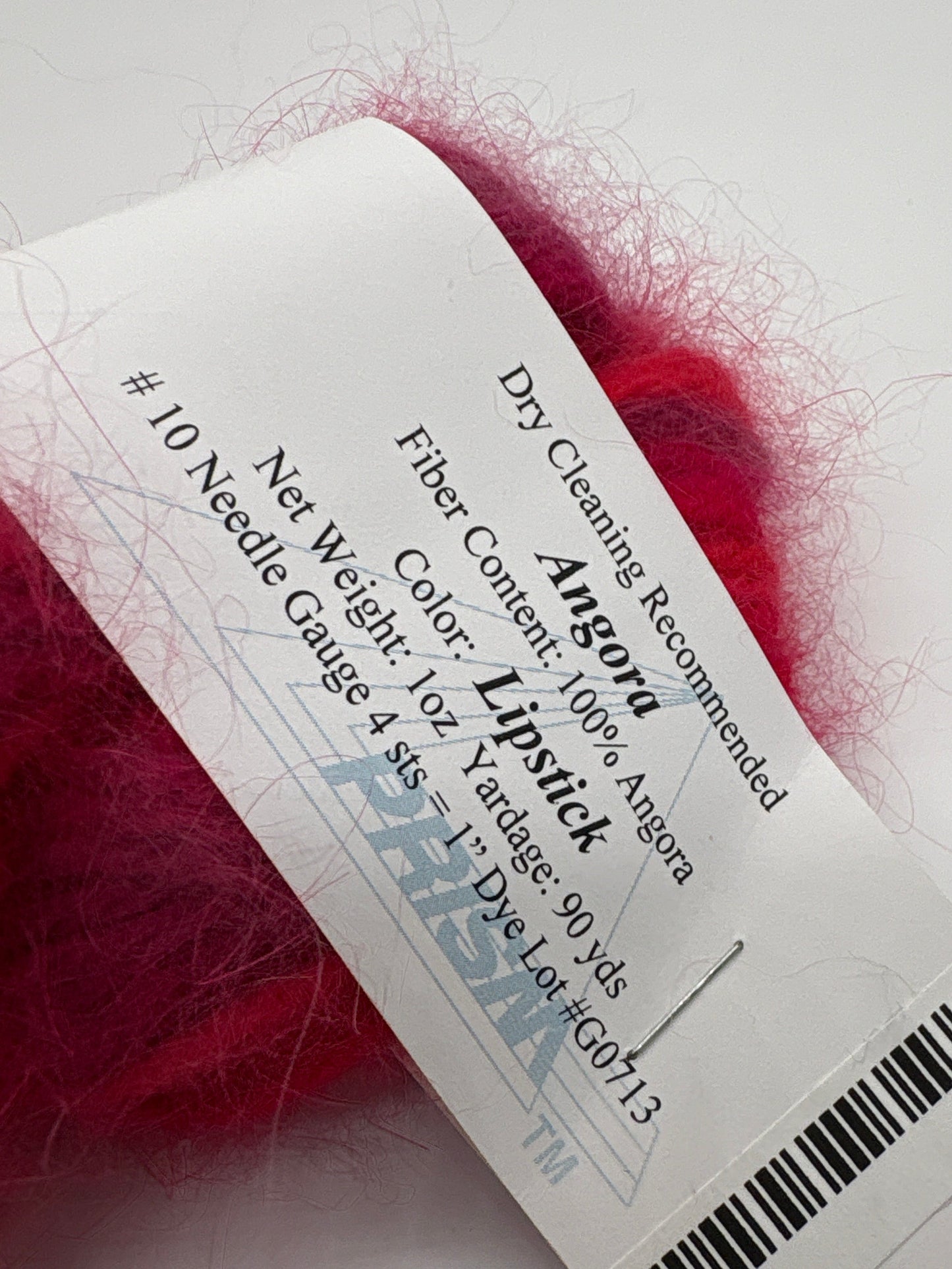 Close-up of Label of 100% Angora Yarn by Prism in the color lipstick on a white background