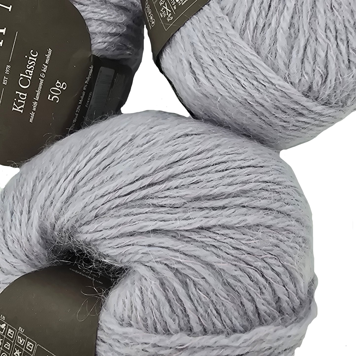 Two skeins of gray yarn with labels on a light background