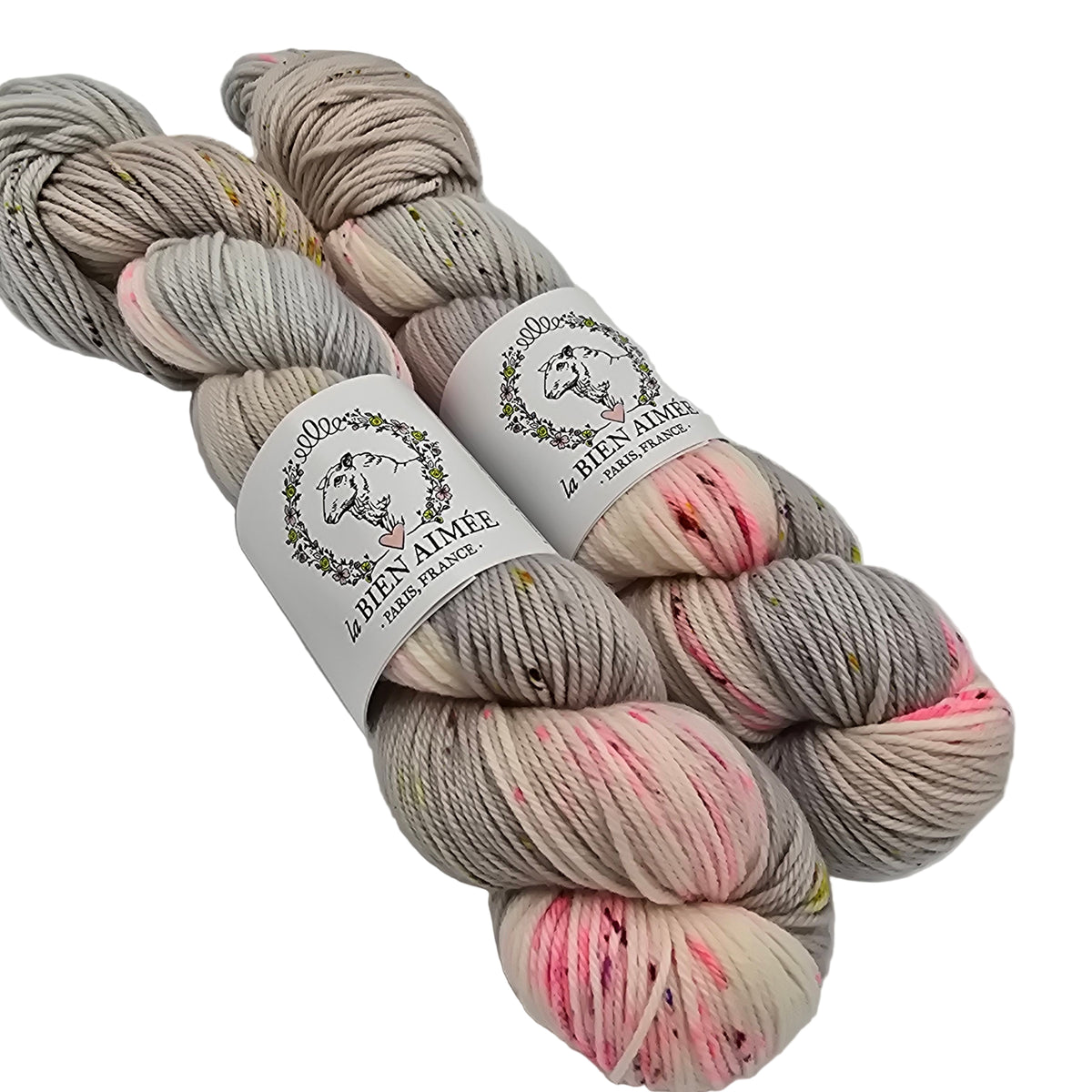 Image of two skeins of wool from the brand La Bien Aimee in the color Fiori (which is a mix of pink, grey and cream) with labels on a white background.