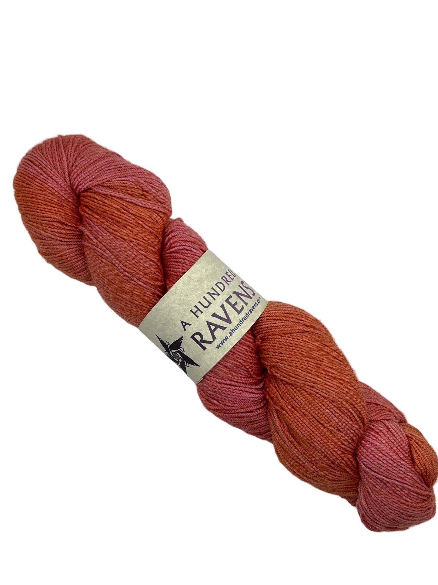 Image of a single skein of Patos Yarn in the color wassail by A Hundred Ravens with label on a white background.
