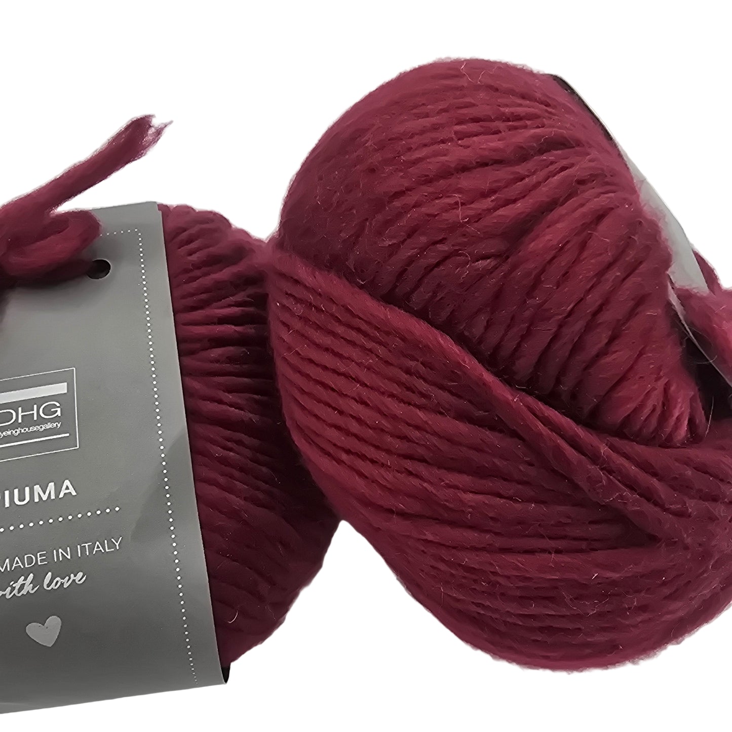 Image of two balls of Piuma by DHG Ultra Soft bulky Italian Merino Wool yarn in the color Soft Fruit which is a solid burgundy with labels on a white background