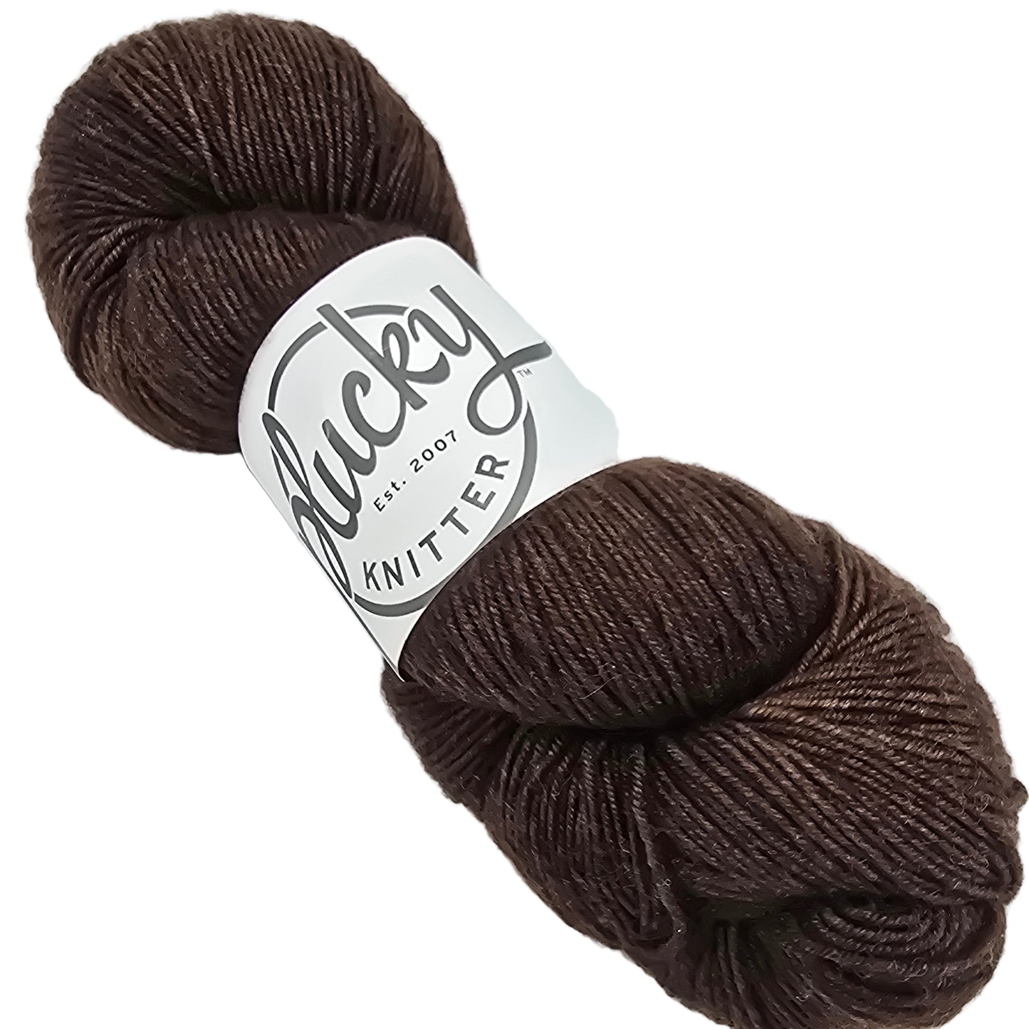 Image of a single skein of yarn by the brand Plucky Knitter in the color Chocolate Crinkle (which is a blend of dark brown with a small amount of cream mixed in) with label on a black background.