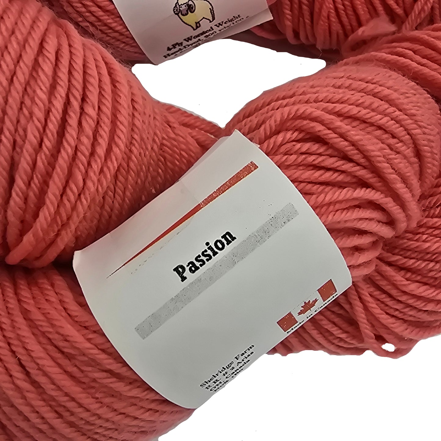 Close-up image of the label on a skein a Shelridge farm brand yarn in the color passion which is a coral pink on a white background.