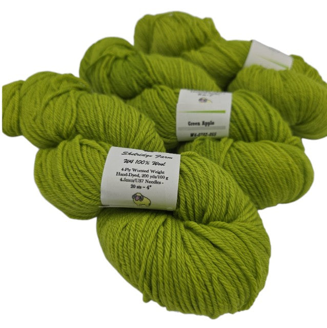 3 skeins of W4 100% Wool Yarn by Shelridge Farm in the color Green Apple with labels on a whitebackground.