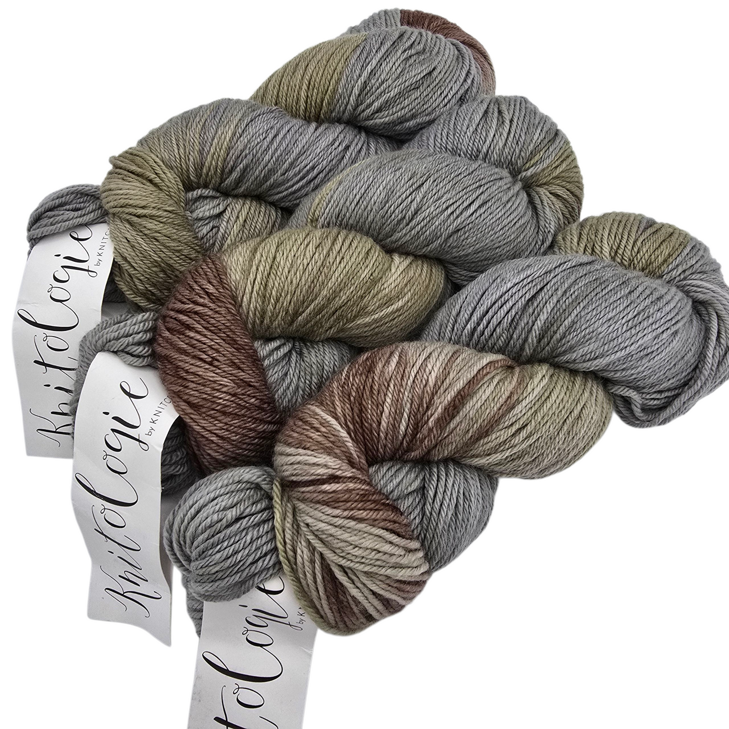 Image of three skeins of multicolored Worsted Merino Yarn by Knitologie in a color called Bohemian Waxing which is a combination of alternating grey, brown and tan with labels on a white background.