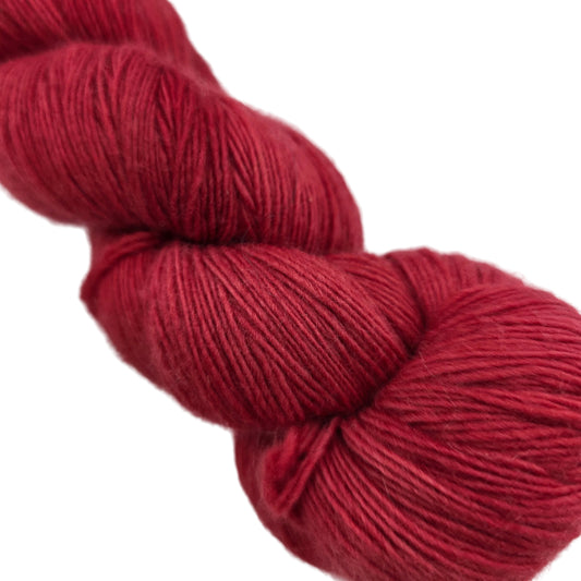 Close-up Image of single hank of Lace by Malabrigo Yarn in color 611 Ravelry Red on a white background.