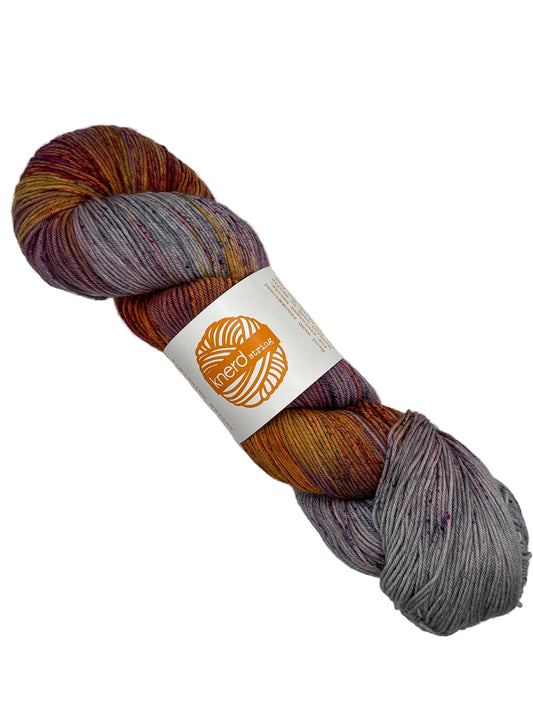 Single Skein of 4-ply Fingering 100% Superwash Merino by Knerd String in multicolor pattern called Flare Up with label on white background.
