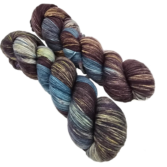 Two skeins of 80/20 Merino Nylon DK Yarn by Arcane Fibre Works in color For All The Trees  on white background. 