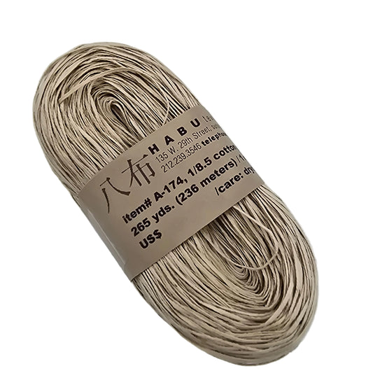 Image of a single hank of A-174 1/8.5 Cotton Gima yarn by Habu Textiles in color 12 with label on a white background.