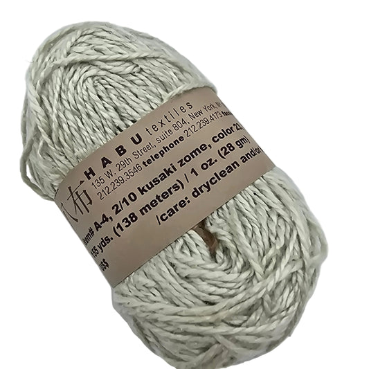 Image of a single skein of A-4, 2/10 Kusaki Zome Yarn by Habu Textiles   in Color 23 with label on a white background.