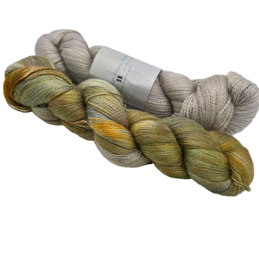 Image of two skeins of Alpaca Silk DK Yarn by Expression Fiber Arts on a white background.