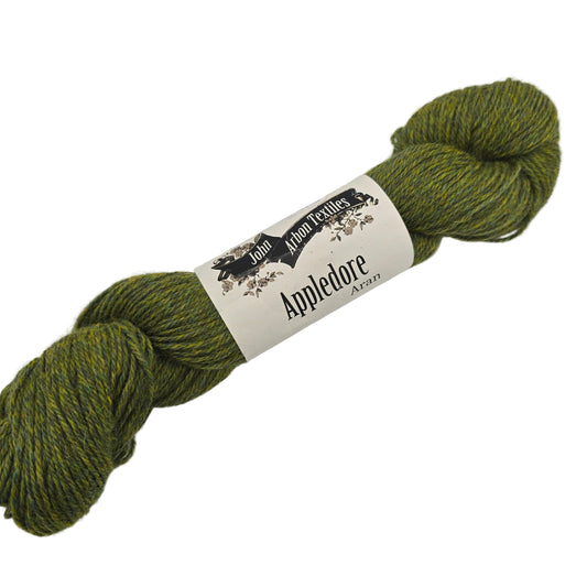 Image of a single hank of Appledore Aran yarn by John Arbon Textiles in the color Spicy Pippin with label on a white background.