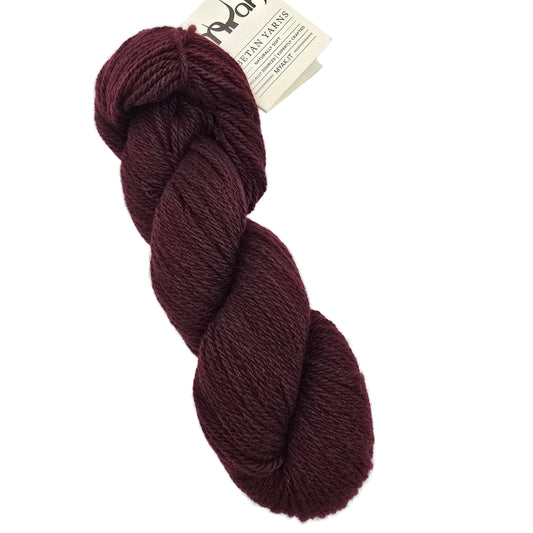 A single hank of dark burgundy yarn with a paper brand tag, photographed on a clean white background.