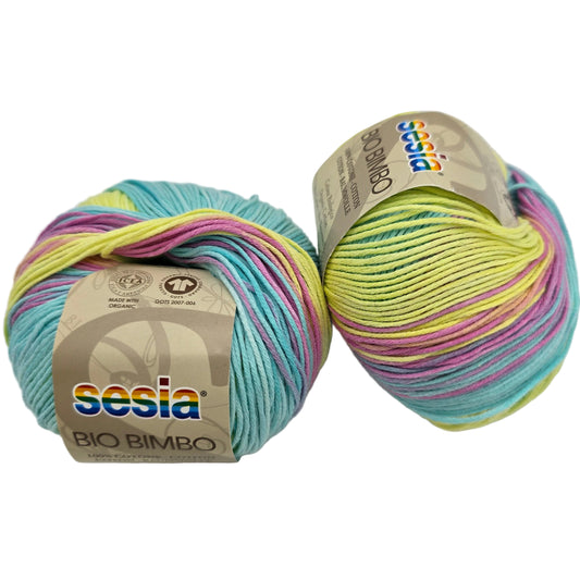 Image of two balls of Bio Bimbo by Sesia yarn in the Color 5047 Sunny Day with labels on a white background.