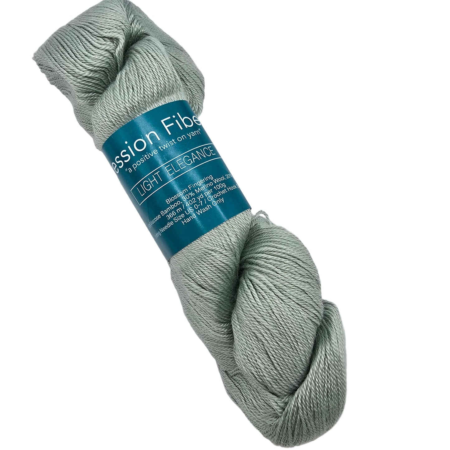 A skein of light sage green Blossom Fingering by Expression Fiber Arts yarn in the color Light Elegance with a teal paper label, photographed on a clean white background.