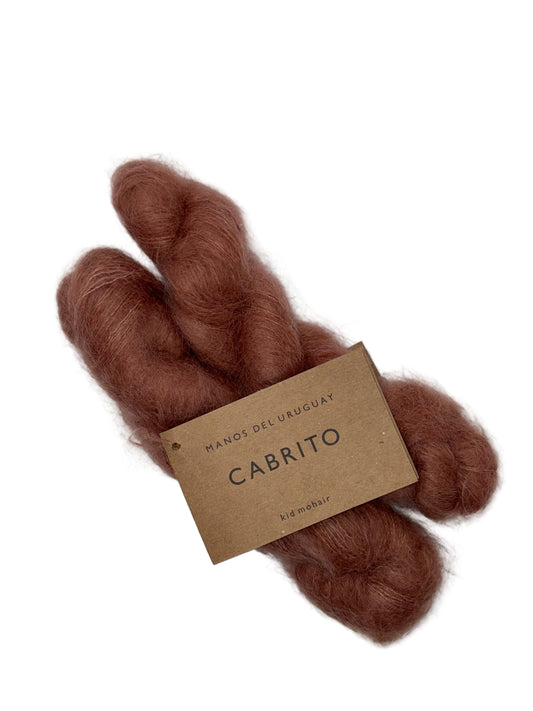 Brown yarn skein with a label on a white background