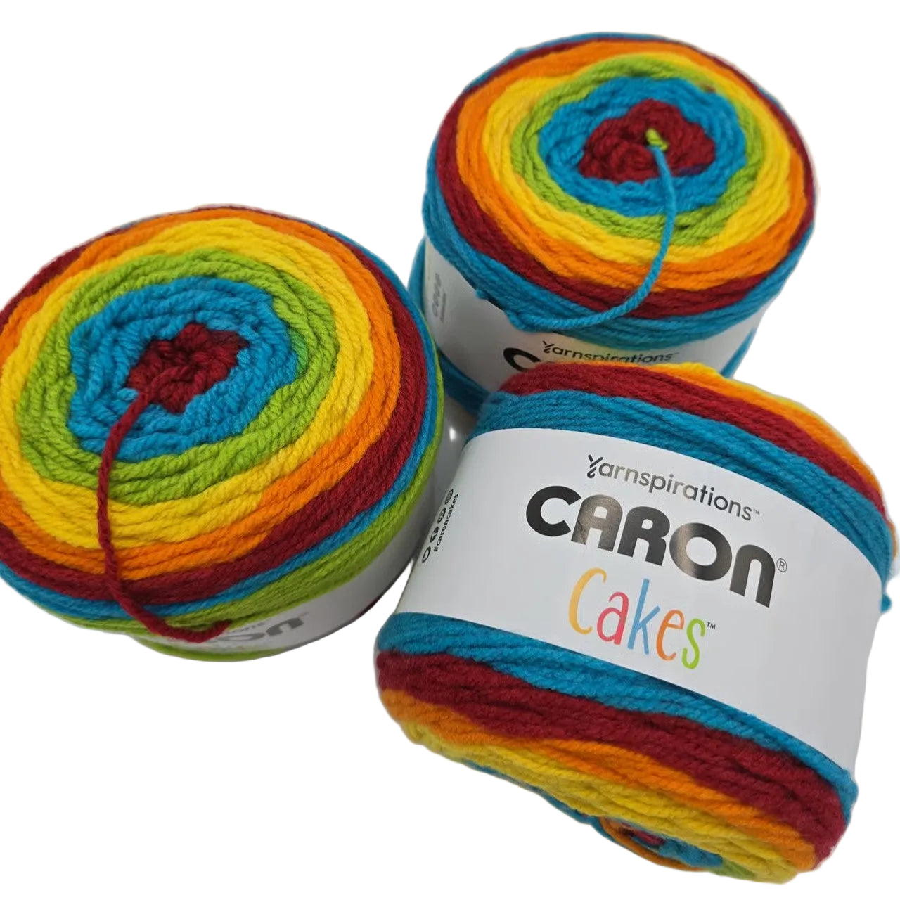 3 cakes of caron of yarn in the color rainbow sprinkles with label on a white background.