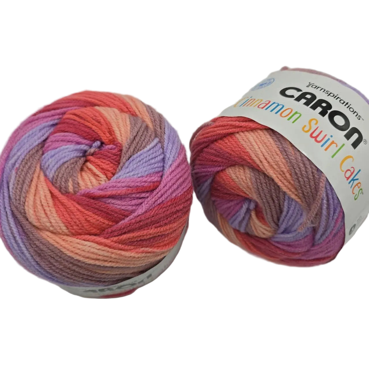Image of two cakes of Caron Cinnamon Swirl Cakes Yarn in the color Hibiscus with labels on a white background.