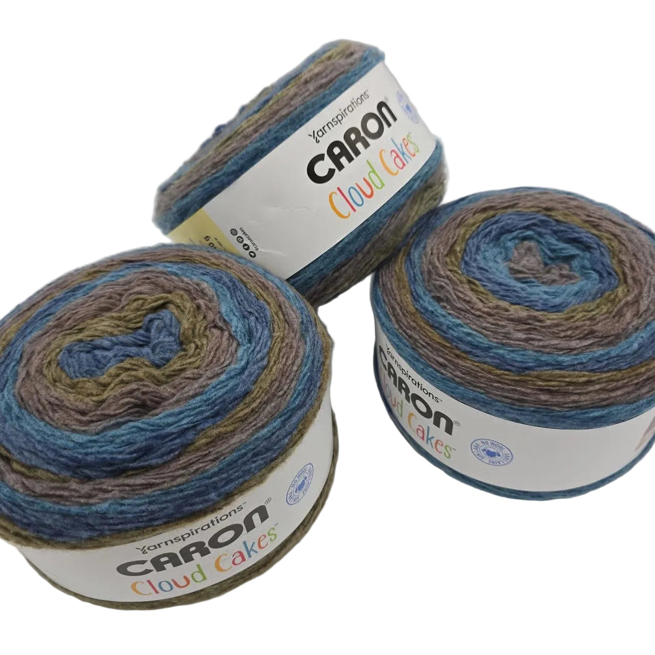 Image of three cakes of Caron Cloud Cake yarn in the color Shore Birds with labels on a white background.