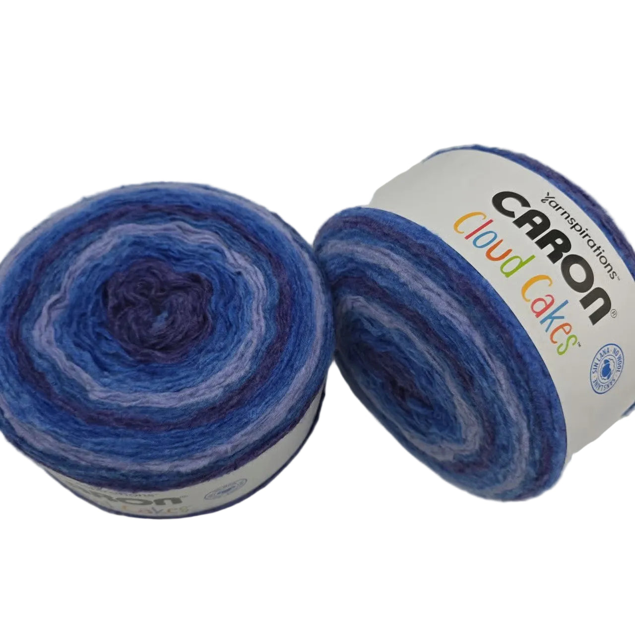 Image of two cakes of Caron Cloud Cakes Yarn in the color Royal Treatment with labels on a white background.