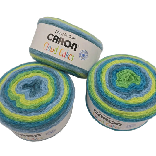 Image of three cakes of Caron Cloud Cakes Yarn in the color Tidal Wave with labels on white background.