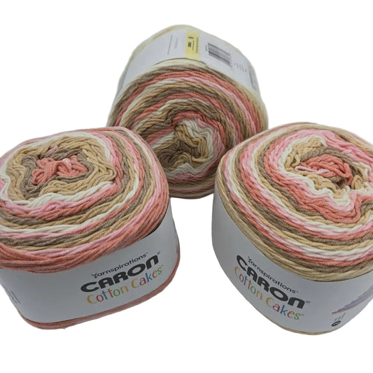 Image of three cakes of Caron Cotton Cakes Yarn in the color Blush & Bloom with labels on a white background.