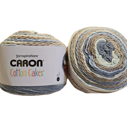 Image of two cakes of Caron Cotton Cakes yarn in the color Nested Blues with label on white background.