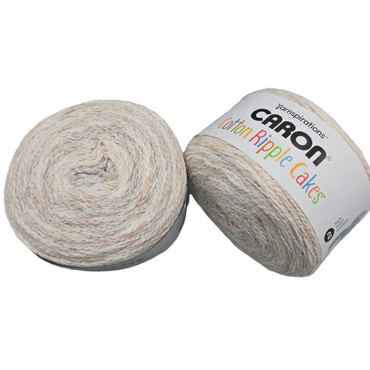 Image of two Caron Cotton Ripple Yarn Cakes in the color French Vanilla with label on a white background.
