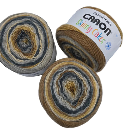 Image of 3 cakes of Caron Skinny Cakes yarn in the color Tiramisu with labels on a white background.