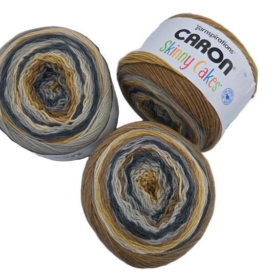 Image of 3 cakes of Caron Skinny Cakes yarn in the color Tiramisu with labels on a white background.