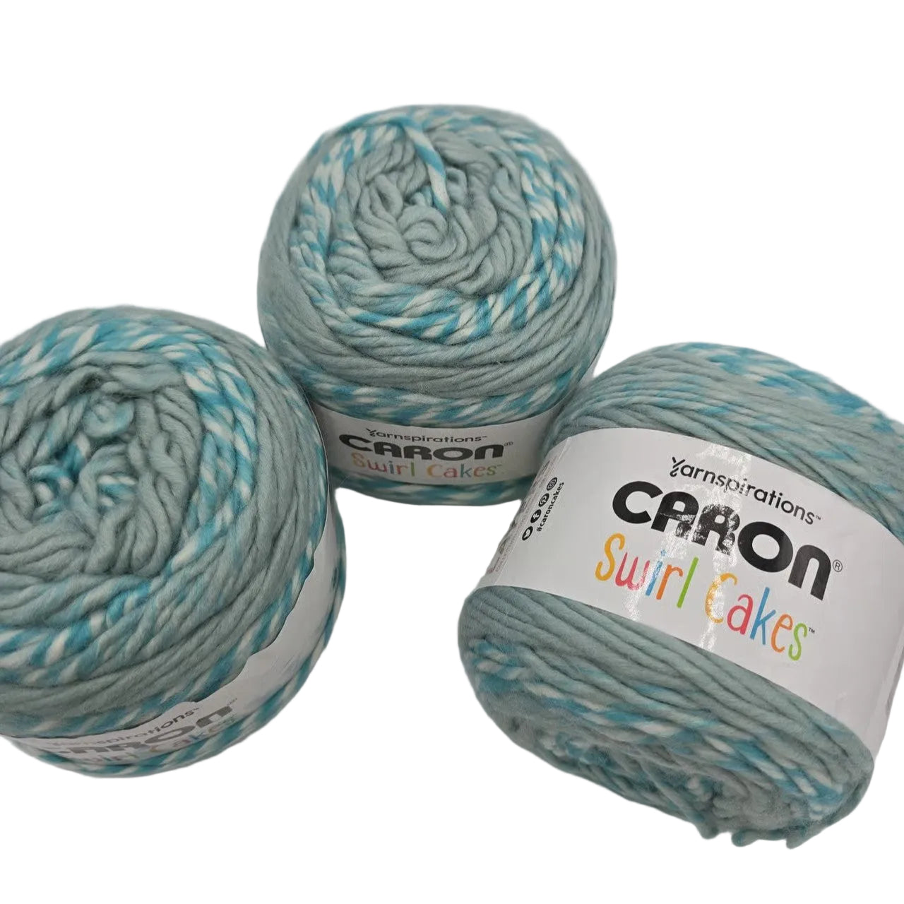 Image of 3 cakes of Caron Swirl Cakes yarn in the color Iced Cream with labels on a white background.