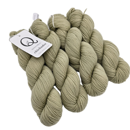 Image of 4 hanks of Chickadee by Quince & Co. in the color Eucalyptus LE with labels on a white background.