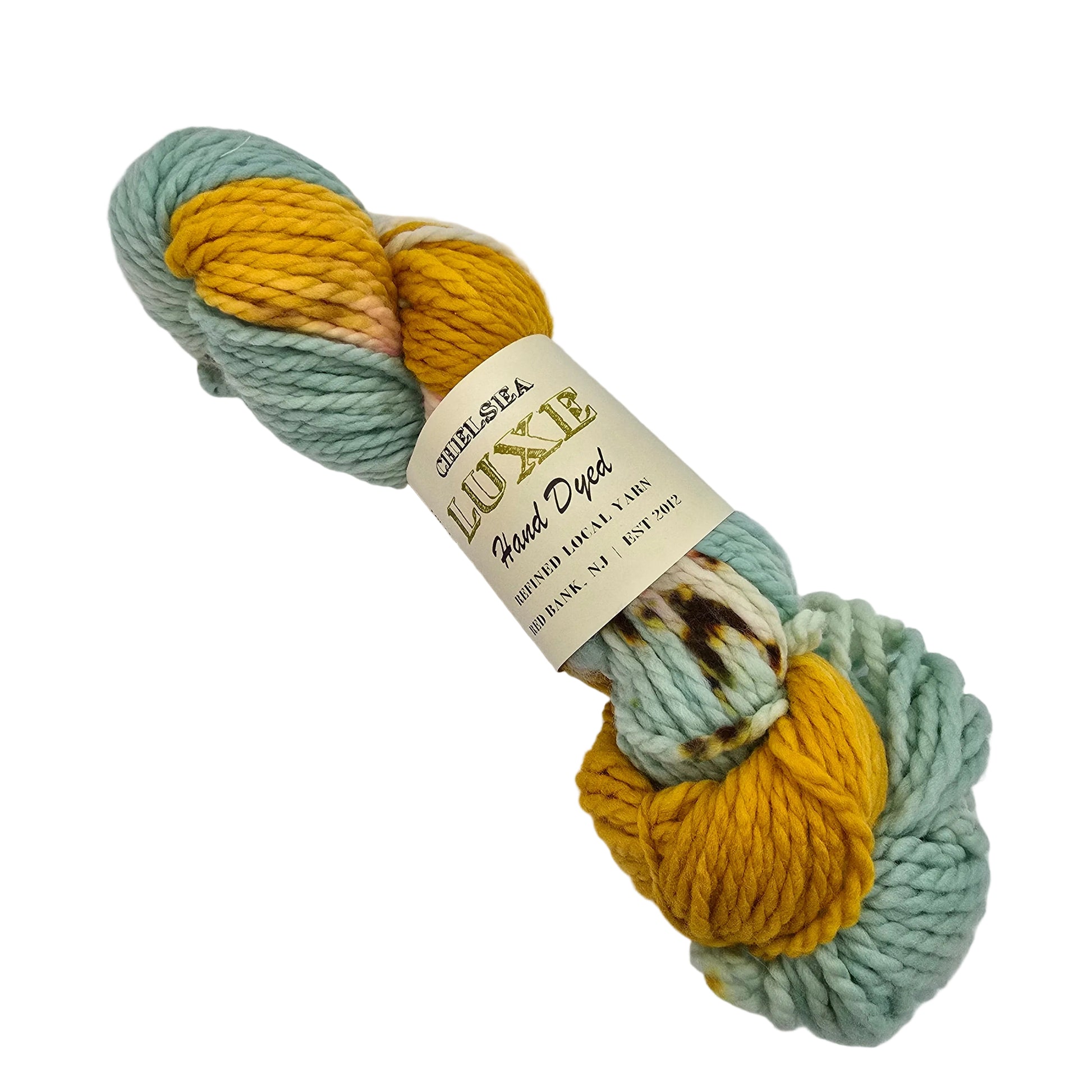 A skein of  Chunky Yarn by Chelsea Luxe  in the color I Love NY a variegated yarn with sections of pale mint green and mustard yellow, wrapped in a cream paper label that reads 'LUXE Mixed Yarn' on a white background.