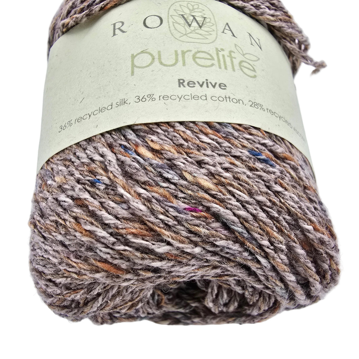 A close-up of a skein of Rowan Purelife Revive yarn in color 462 Basalt showing its variegated brown, gray, and beige twisted fibers with a light green paper label.