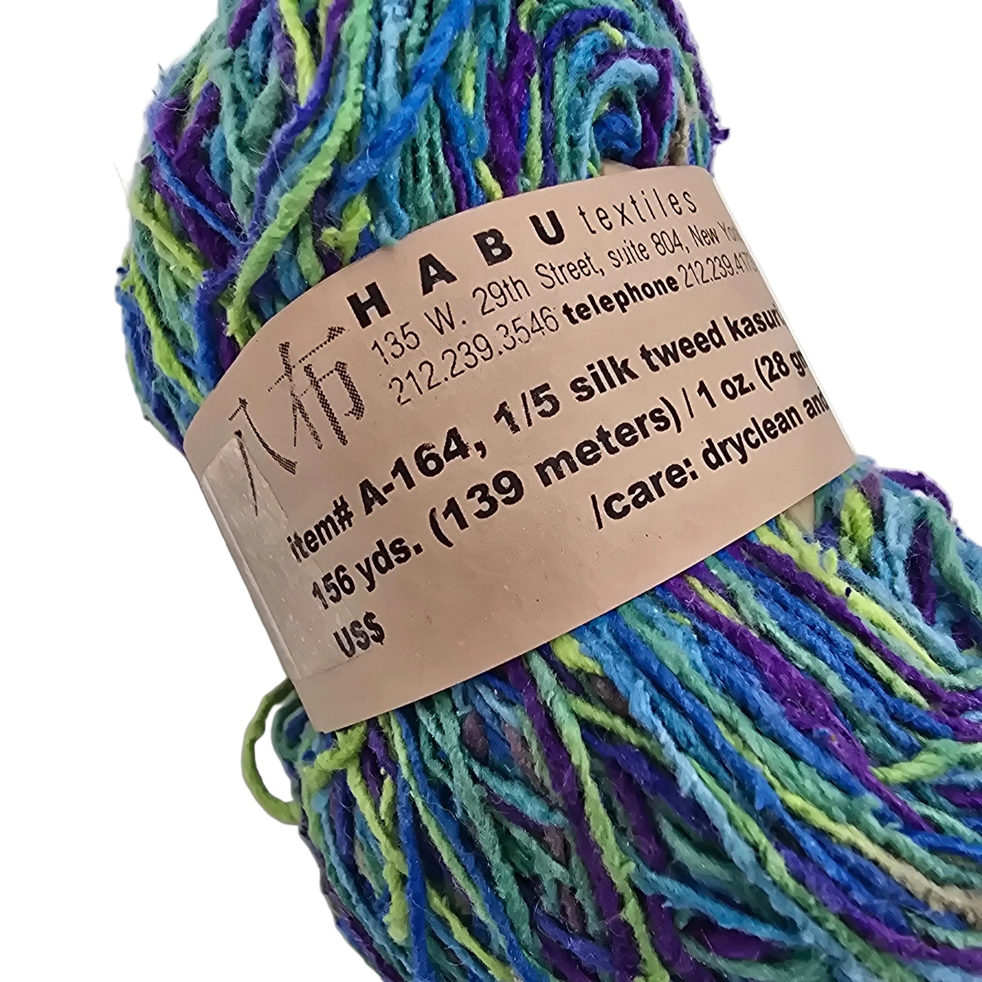 Close-up Image of a single hank of A-164 1/5 Silk Tweed Kasuri Yarn by Habu Textiles in the Color L9 with label on a white background.