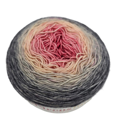 Close-up image of a single cake of Aerialist 150 Fingering by Knit Circus  in the color Come What May on a white background.