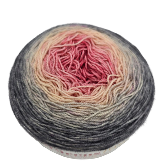 Close-up image of a single cake of Aerialist 150 Fingering by Knit Circus  in the color Come What May on a white background.
