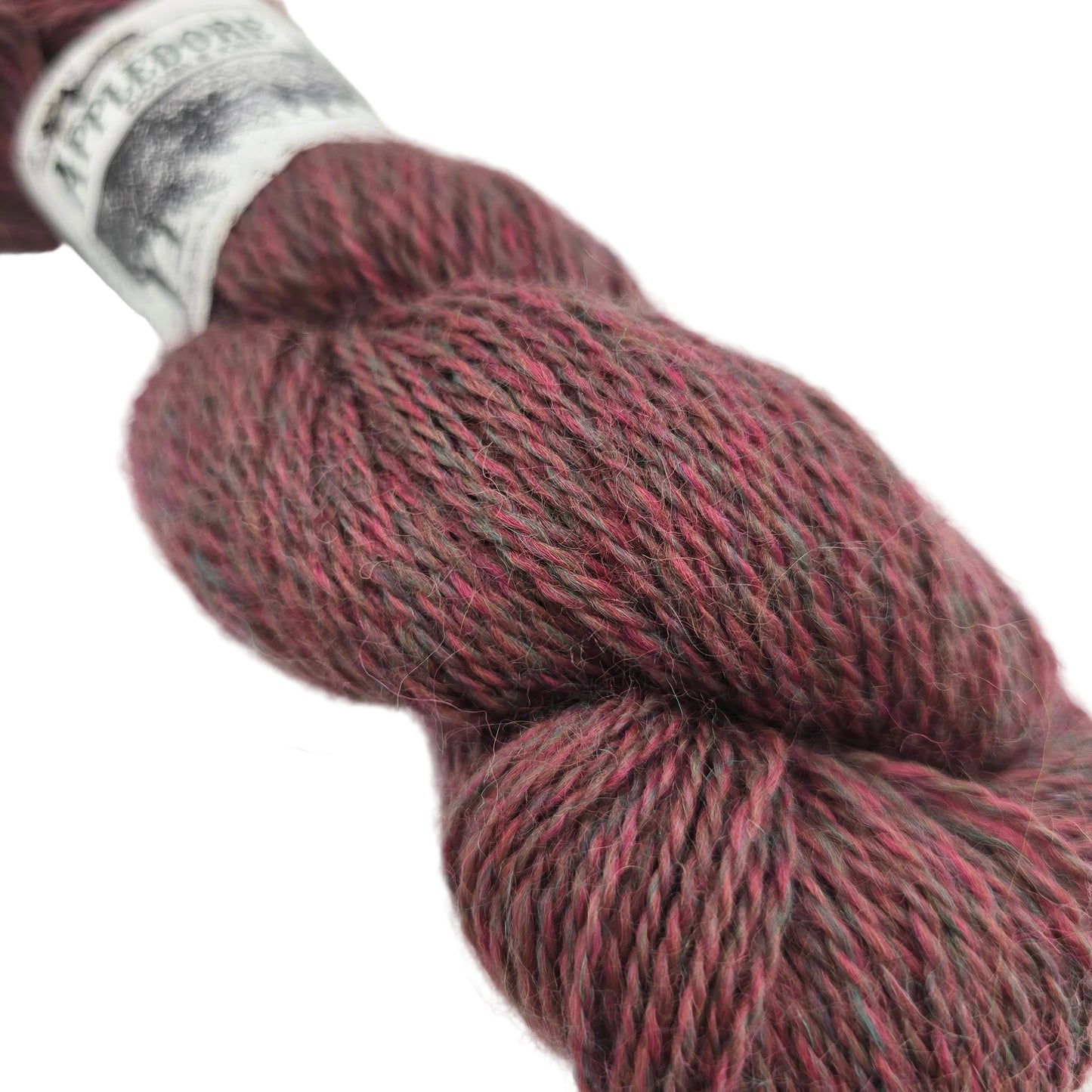 Close-up image of Appledore DK  yarn by John Arbon Textiles  in the color Sweet Coppin with a partial label on a white background.