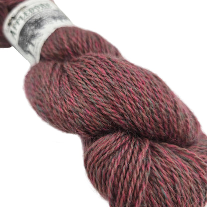 Close-up image of Appledore DK  yarn by John Arbon Textiles  in the color Sweet Coppin with a partial label on a white background.