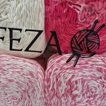 four balls of variegated yarn arranged in a square, with the brand name 'FEZA' and a knitting icon printed in black across the center. The yarn colors alternate between white, bright pink, and a pink-and-white marled pattern.