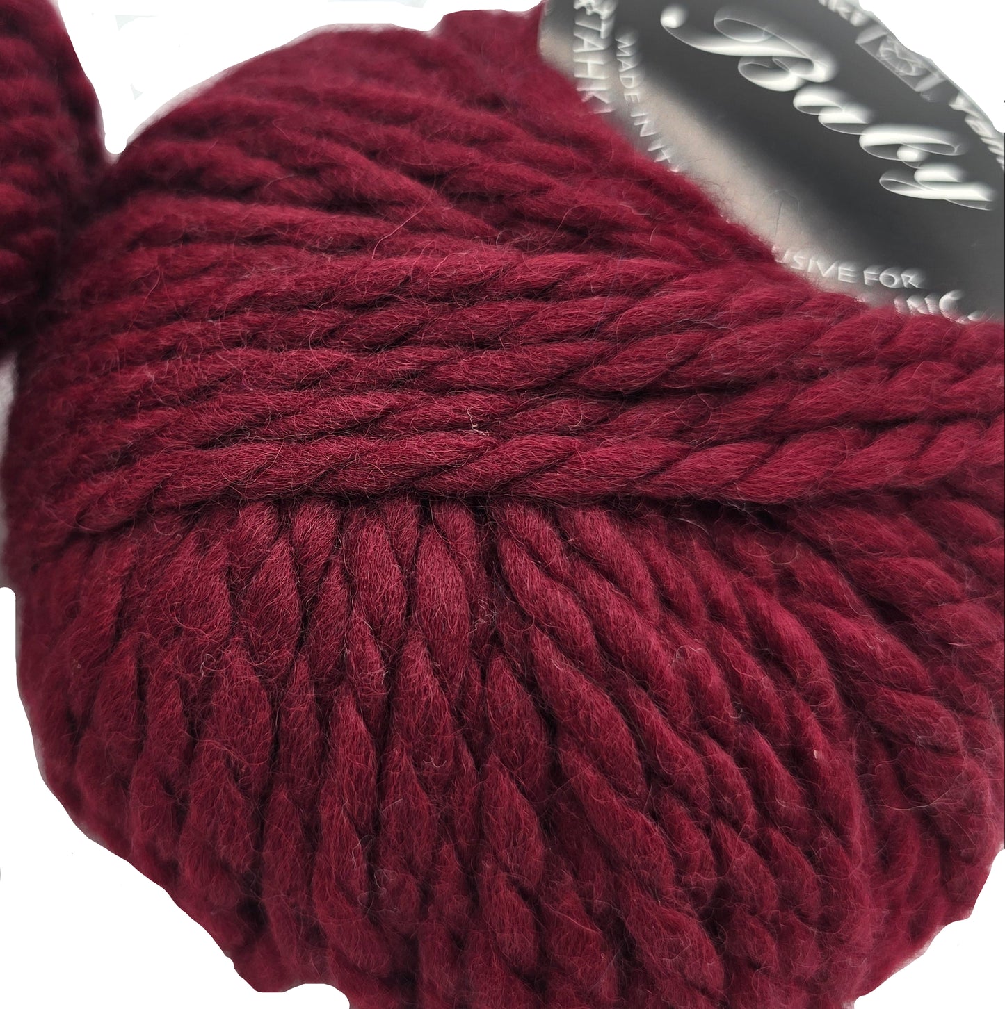 Close-up image of Baby by Tahki yarn in color 32 with partial label on a white background.