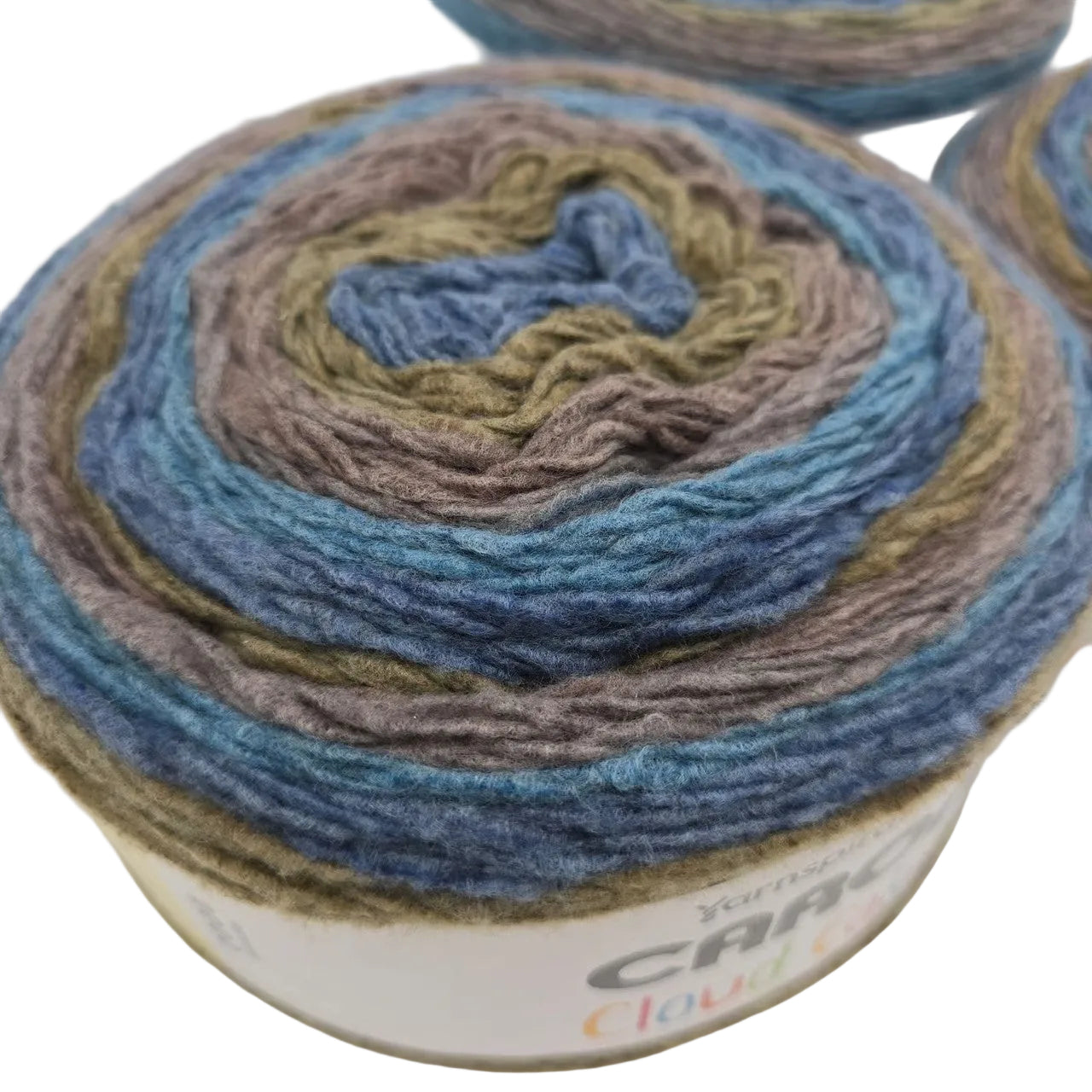 Close-up image of Caron Cloud Cake yarn with label in the color Shore Birds on a white background.
