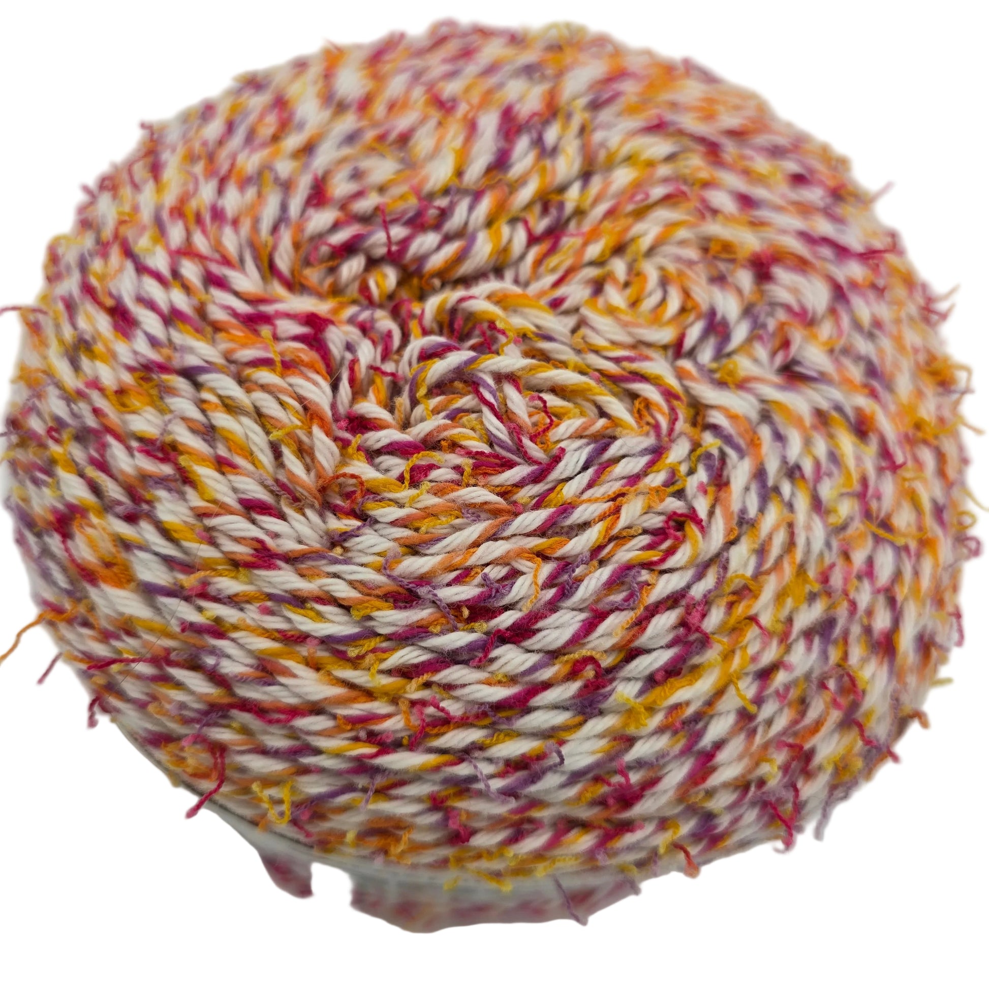 Close-up image of a single cake of Caron Coconut Cakes yarn in the color Tutti Frutti on a white background.