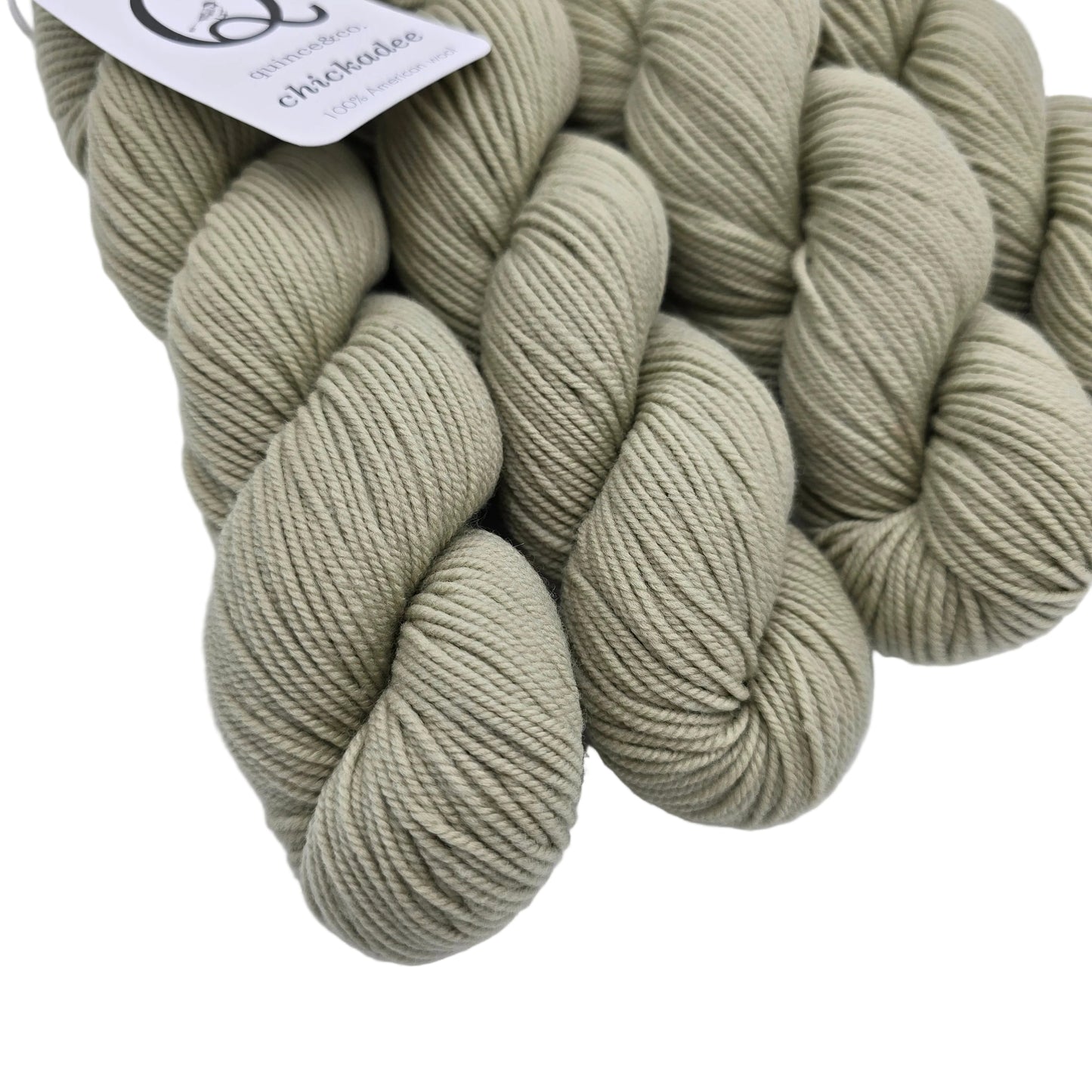 Close-up image of Chickadee Yarn by Quince & Co. in the color Eucalyptus LE with partial label on a white background.